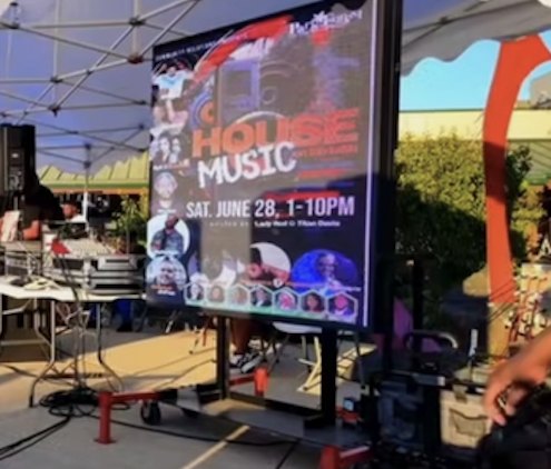 A Haul Adz LED screen set up under a canopy at an outdoor event