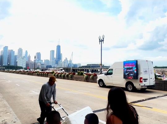 The Haul Adz LED truck driving the Chicago lakefront with the skyline behind it during the Air & Water Show